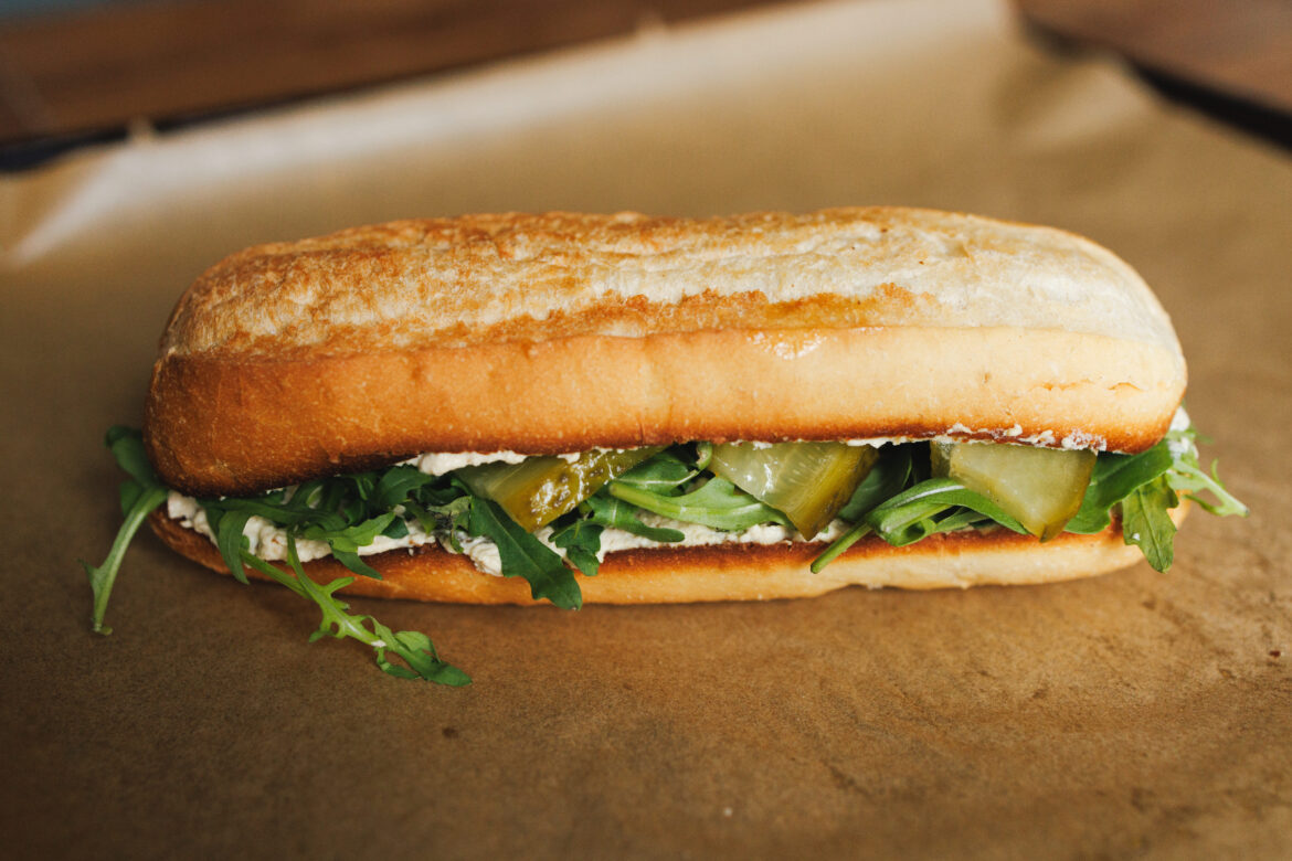 Křupavá veganská bageta s tofu pomazánkou, kyselou okurkou a rukolou